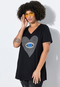 Schwarzes V-Ausschnitt-T-Shirt mit einem Herzdesign aus Strasssteinen, das ein zentrales Augensymbol in Blau und Silber zeigt. Weicher Stoff, lässige Passform.