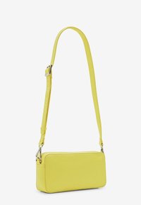 Żółta skórzana torebka na ramię w kształcie prostokąta, z regulowanym paskiem i srebrnym okuciem. Gładka tekstura o minimalistycznym designie.