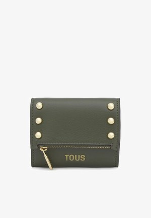 Portefeuille en cuir vert olive avec six clous dorés, poche zippée dorée et logo "TOUS" embossé en or sur le devant.