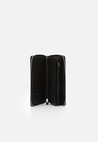 Portefeuille noir zippé avec plusieurs emplacements pour cartes, un compartiment zippé et un intérieur texturé. Matériau en cuir lisse avec un design minimaliste.