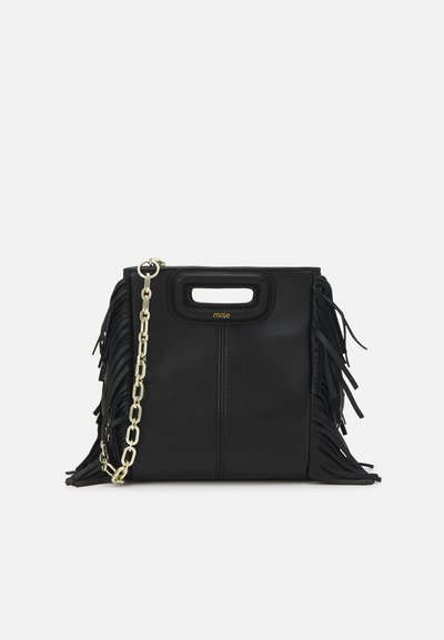 Black leather handbag with fringe details, gold chain shoulder strap, and a cut-out handle. Features logo placement on the front.