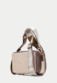 Sac bandoulière beige en cuir texturé, logo embossé "Since 90", double compartiments zippés et sangle ajustable à motif.