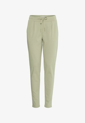 Pantaloni della tuta verde chiaro realizzati in tessuto morbido, con un elastico in vita regolabile, tasche laterali e un design gamba affusolata.