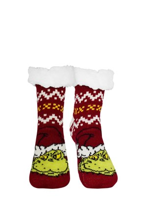 Red Christmas socks with white fluffy cuffs, featuring a yellow Grinch face wearing a Santa hat and white and yellow patterned knit design.