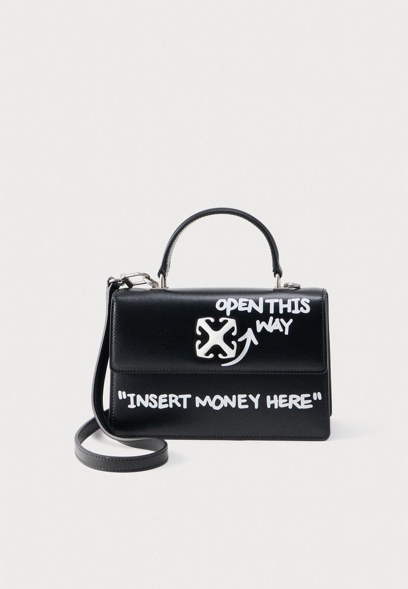 Μαύρη δερμάτινη τσάντα χειρός με λευκό γκράφιτι κείμενο «ΑΝΟΙΞΤΕ ΑΠΟ ΕΔΩ» και «ΒΑΛΤΕ ΛΕΦΤΑ ΕΔΩ», με επάνω χερούλι και αποσπώμενο ιμάντα ώμου.