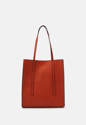 Grand sac cabas rectangulaire en cuir marron avec de longues poignées fines et une surface lisse et sans ornement sur fond clair.