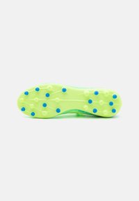 Suola di scarpino da calcio verde con superficie testurizzata, tacchetti rotondi e accenti blu. Progettata per la trazione su superfici di erba naturale.