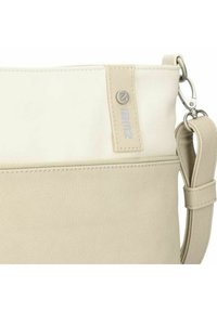 Bolso de hombro sintético beige con una textura suave, que presenta un cierre con cremallera, correa ajustable y un sutil detalle del logo.