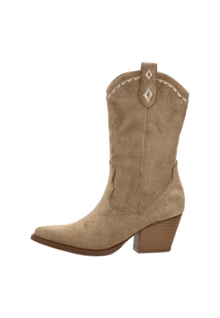 Botas de cowboy de ante en color tostado con punta afilada y tacón apilado. Presentan costuras decorativas y un acento en forma de diamante en el cañón.