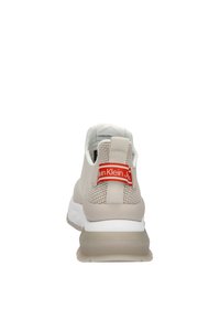Světlé béžové sportovní boty s texturovaným síťovaným svrškem, bílou podrážkou a červeným logem na patě. Obsahují polstrovaný límec.