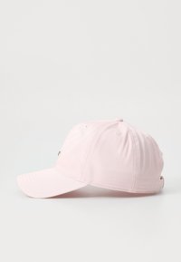 Casquette de baseball rose en tissu texturé, avec une visière incurvée et un petit logo brodé à l'avant. Elle dispose de trous de ventilation et d'une sangle réglable à l'arrière.