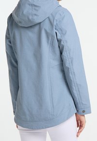 Ljusblå, huva jacka med en slät textur, som har en rak skärning, sidsömmar och knappdetaljer vid ärmsluten.