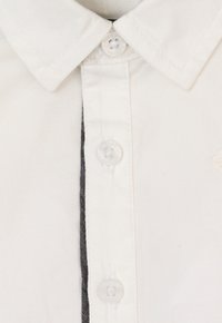Witte button-up shirt met een klassieke kraag, transparante knopen en zwarte contrasterende stiksels langs de voorplacket.