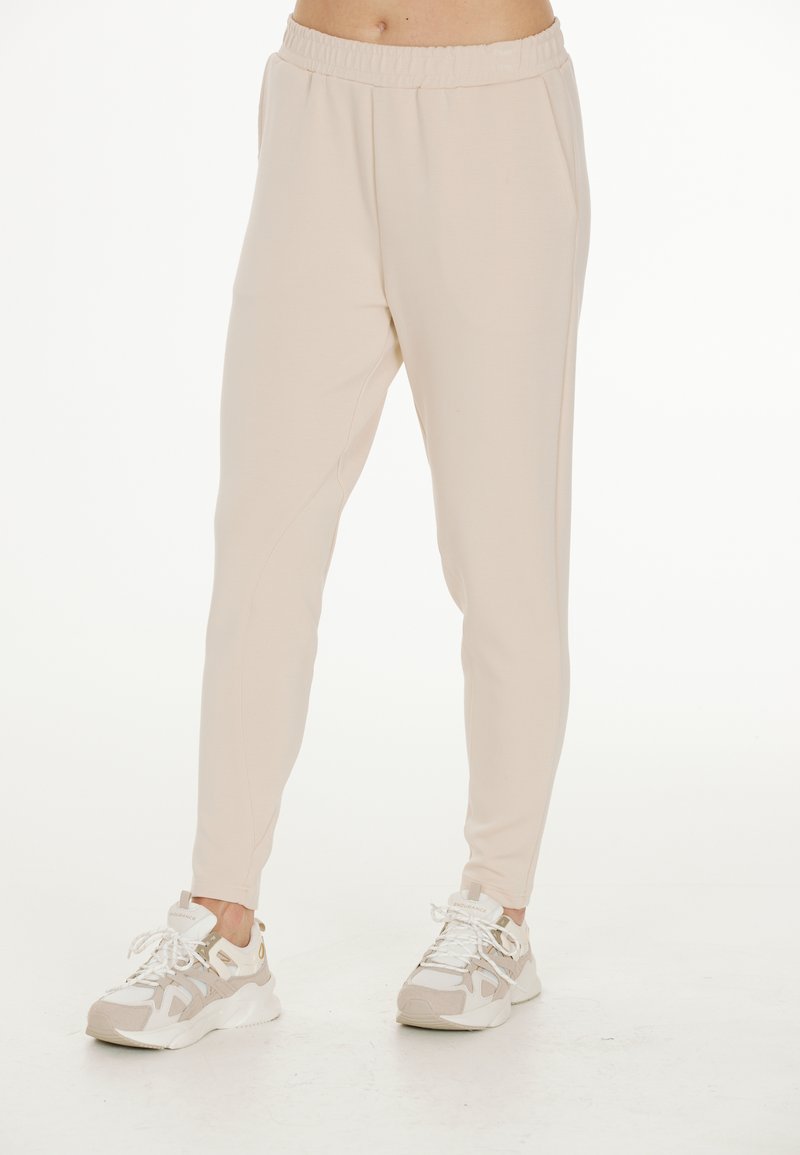 Ljusbeige joggers i mjukt material med elastisk midja, har en taperad passform och sidofickor. Matchas med vita sneakers.