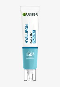 Tubo di crema solare con corpo bianco e dettagli turchesi. Il testo evidenzia "Hyaluron Daily UV Invisible" e SPF 50+. Cappuccio trasparente che rivela l'ugello.