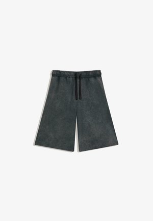 Schwarze Shorts mit weitem Bein, elastischem Bund und schwarzem Kordelzug, flach auf einem weißen Hintergrund liegend.