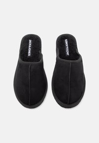 Mustade libisemiskindlate siseruumide susside paar pehme, karvase sisetükkiga ja "JACK & JONES" brändingu ning siseosaga, vaadatuna ülalpool.