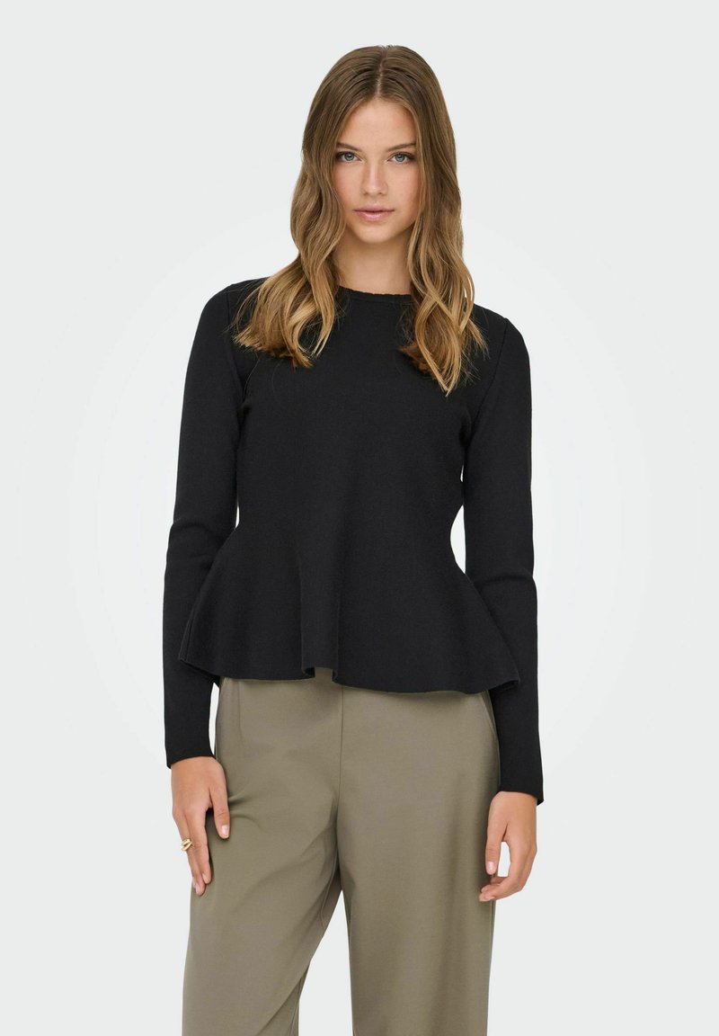 Musta, pitkähihaisen yläosa, jossa istuva vartalo ja levenevä helma. Pehmeä pinta, pyöreä pääntie, yhdistetty vaaleisiin housuihin.