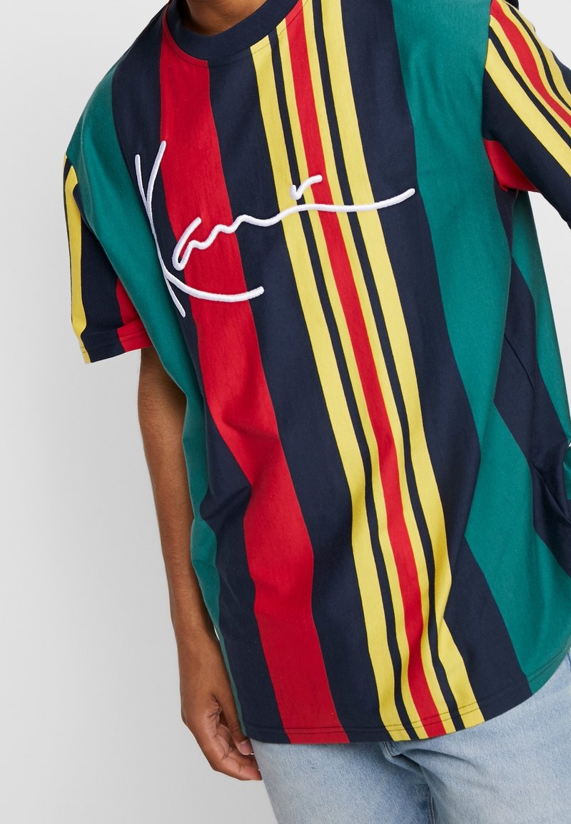 Kortärmad, flerfärgad bomulls t-shirt med vertikala ränder i röd, gul, grön och marinblå, med en vit broderad logotyp.