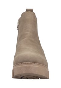 Botín beige hasta el tobillo hecho de un material tipo ante, con una textura suave, cremallera lateral y una suela gruesa y texturizada.