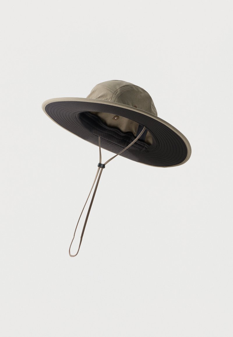 Καπέλο παραλλαγής με φαρδύ γείσο, σκοτεινή κάτω επιφάνεια και ρυθμιζόμενο λουράκι στο πηγούνι, σε απλό λευκό φόντο.