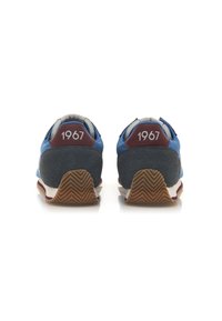 Sneaker retro blu e grigie con suede texturizzato e gomma. "1967" stampato sul tallone, con un motivo a zigzag sulla suola.