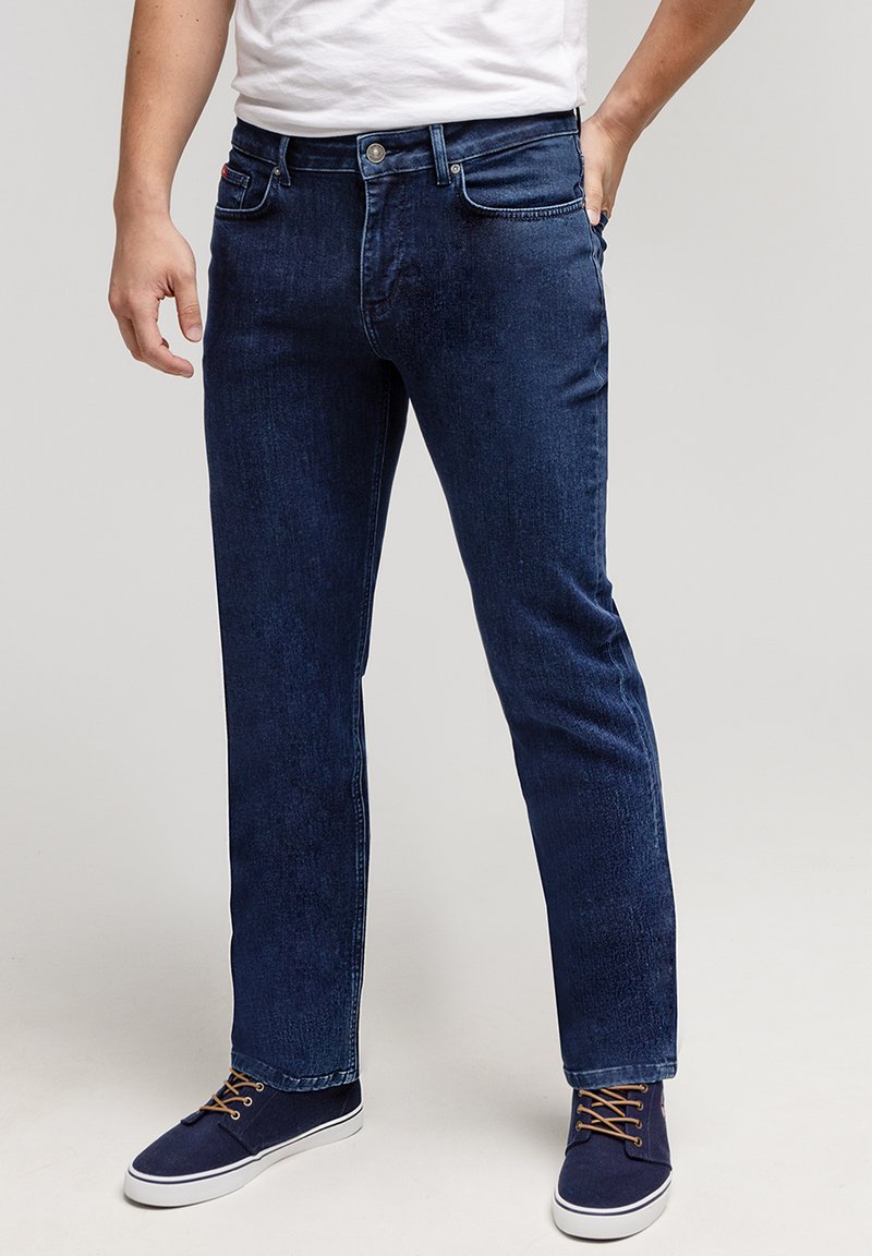 Jasnoszare dżinsy w ciemnoniebieskim kolorze, prosty krój z delikatnym wyblakłym odcieniem. Posiadają klasyczne szlufki na pasek, kieszenie z przodu oraz zapięcie na guzik.