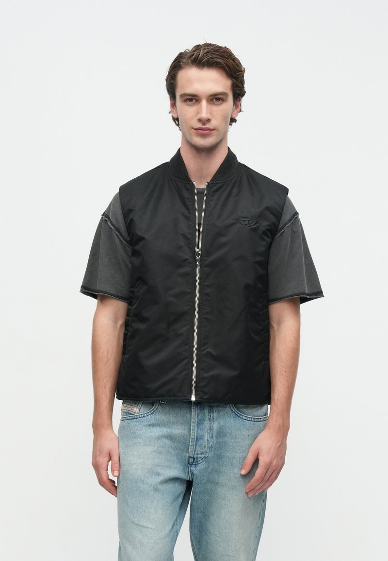 Schwarze Weste mit Reißverschluss im Bomber-Stil, mit kurzen grauen Ärmeln, glatter Textur und dezentem Logodetail auf der Brust.