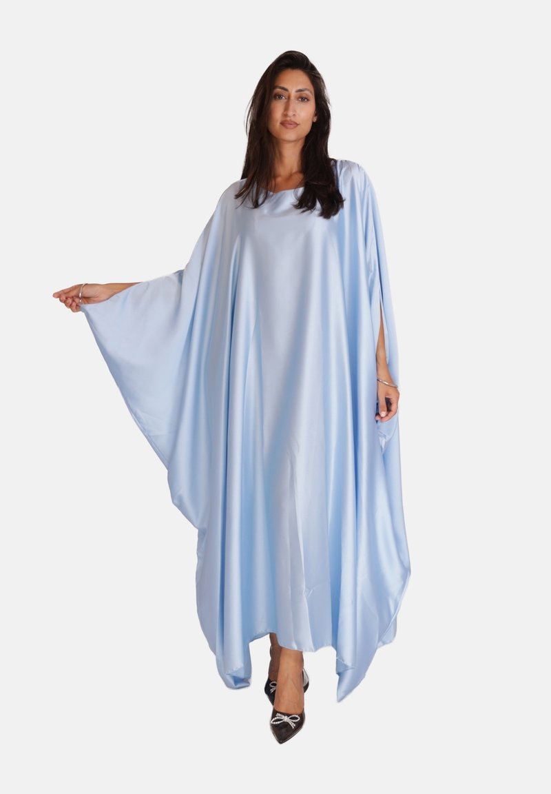 Lichtblauw, vloeiende kaftan van soepel materiaal, met brede mouwen en een losse pasvorm. G gedragen met zwarte schoenen, wat een contrasterende look oplevert.