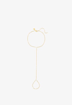 Delicate gold hand chain with a bracelet linked to a loop designed to fit around a finger, displayed on a white background.