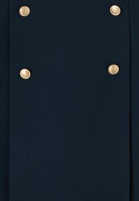 Tissu bleu marine à la texture lisse, comportant quatre boutons dorés sur le devant, chacun orné d'un motif semblable à une pièce de monnaie.