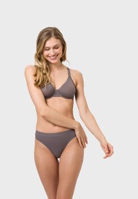 Grüner BH und passender Bikini-Unterteil aus glattem Stoff. Der BH hat eine dreieckige Form mit verstellbaren Trägern und einem weichen Bund.