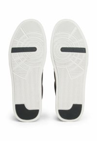 Sneaker neri con suola in gomma bianca testurizzata, caratterizzata da un motivo a spina di pesce e un logo del marchio al centro.