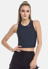 Navy crop top yang terbuat dari kain halus, memiliki leher bulat dan logo bordir di bahu. Dipadukan dengan celana cargo hitam.