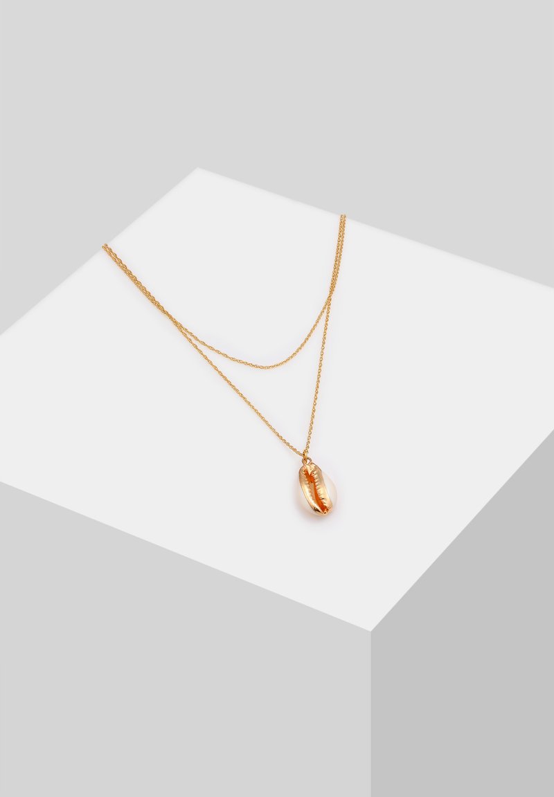 Goudtonen dubbele ketting met een gepolijste schelpvormige hanger met een gladde textuur en een glanzende afwerking.
