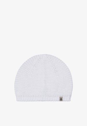 White knitted beanie with a textured pattern and a small rectangular patch near the ribbed edge on a plain background.