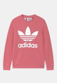 Sweatshirt en coton rose à manches longues, col rond, avec un grand logo adidas blanc et trois bandes parallèles sur un design de feuilles.