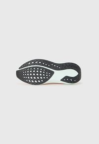 Semelle de chaussure en caoutchouc noir avec un motif de grip texturé et des accents vert menthe clair. Forme incurvée avec un bord lisse et flexible.