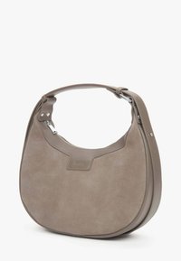 Szara zamszowa torba na ramię o zaokrąglonym kształcie, gładkie skórzane akcenty, regulowany pasek i zamek błyskawiczny u góry. Logo widoczne z przodu.