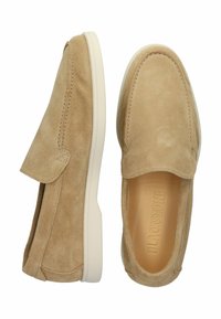 Kreminės zomšinės slip-on tipo bateliai su apvalia nosimi, balta guma pagaminta pada ir siuvinėjimo akcentais aplink kraštus, kad būtų pridėta detalių.