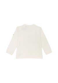 Maglietta bianca a maniche lunghe con scollo tondo e chiusura con bottoni sul retro. Tessuto morbido con una superficie liscia e un sottile logo sulla manica.
