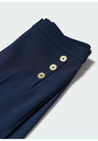 Pantalons navy avec une texture lisse, dotés de trois boutons dorés sur le côté et d'une coupe ajustée.