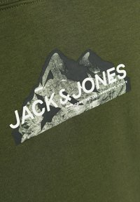 Tessuto verde oliva con una grafica testurizzata di montagne in bianco e nero; presenta il testo "JACK & JONES" stampato in modo prominente sotto.