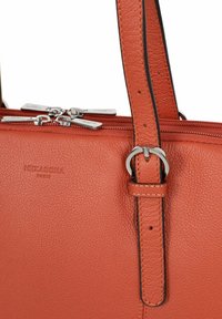 Borsa a tracolla in pelle arancione con texture, dotata di doppie zip argentate e tracolla regolabile fissata da una fibbia in argento.