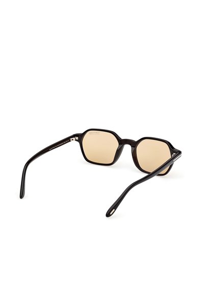 Kuusikulmaiset aurinkolasit, joissa on kiiltävä musta muovikehys ja tummennetut beige linssit. Ohuet mustat sangan varret, joissa on hienovaraisia hopeisia yksityiskohtia.