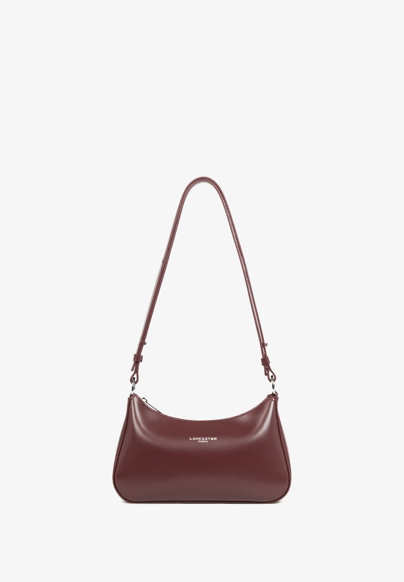 Borsa a spalla in pelle bordeaux con forma curva, tracolla regolabile e chiusura con zip; presenta un branding minimale sulla parte anteriore.