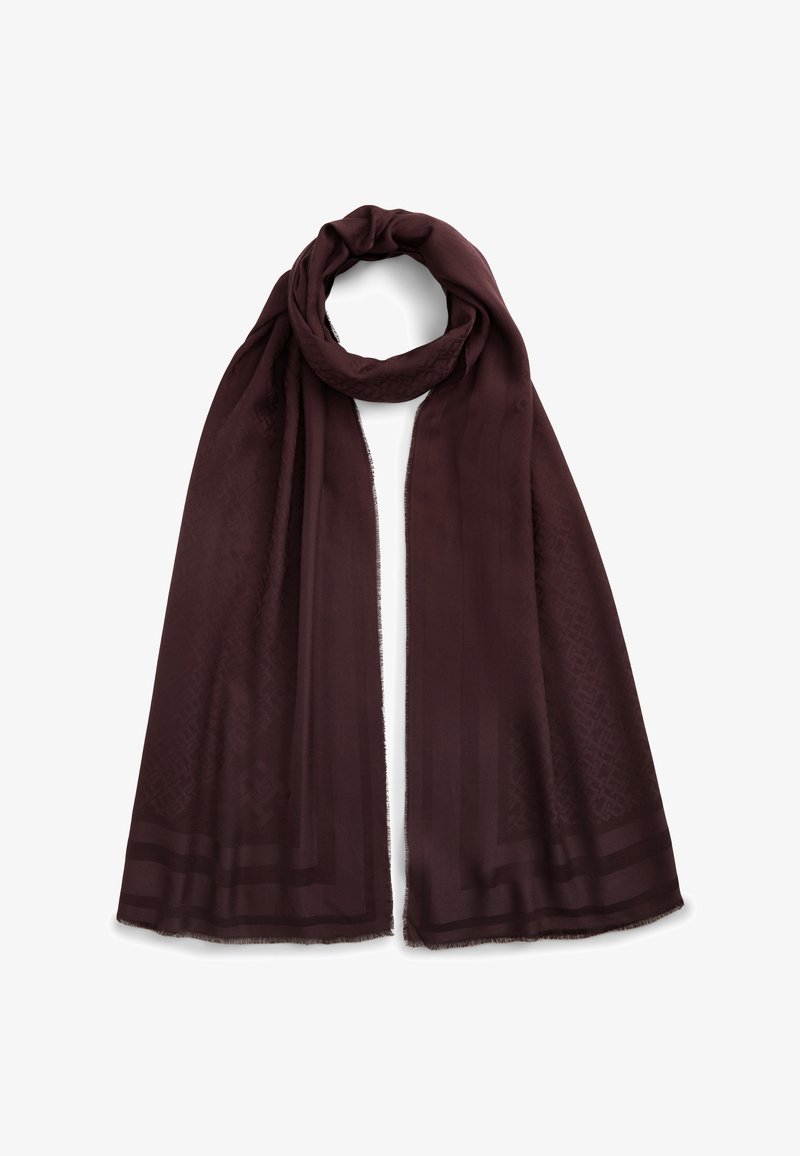 Longue écharpe marron foncé avec une texture subtilement imprimée et des bords à franges, bouclée librement en haut sur fond blanc.
