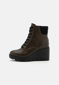 Brown leather ankle boot with a black ribbed collar, lace-up front, and chunky black wedge sole. Features textured accents and smooth finish.
