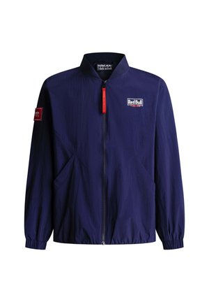 Navyblauw jack met rits en het Red Bull Racing-logo op de borst, een rode ritsluiting en een patch op de linker mouw, met elastische boorden en zoom.