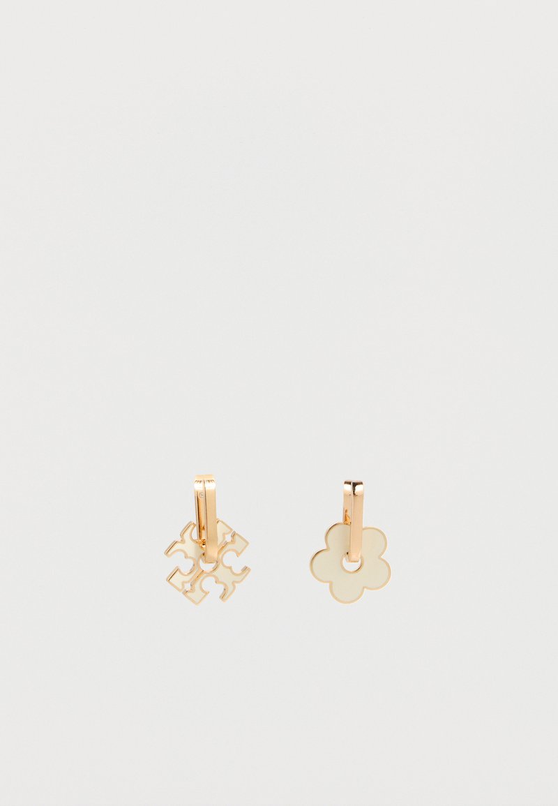 Σκουλαρίκια κρίκοι σε χρυσό με κρεμαστά στοιχεία σε σχήμα λουλουδιού και τριφυλλιού σε εκρού χρώμα, πάνω σε λευκό φόντο.